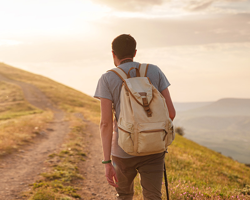 Man walking a path through a field; Find a new path with trauma/ptsd therapy in Bellevue, WA